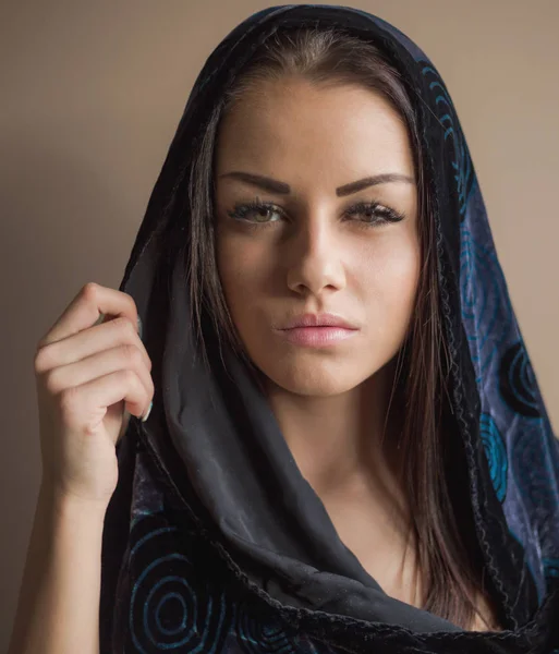 Kahverengi zemin üzerine koyu mavi eşarp genç kadın portresi