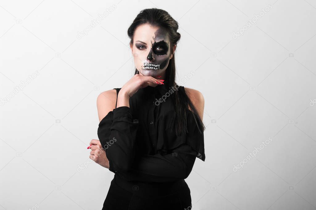 Portrait of young woman with painted skull on face