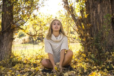 Dışarıda elinde süveterle bir kadının sonbahar portresi.