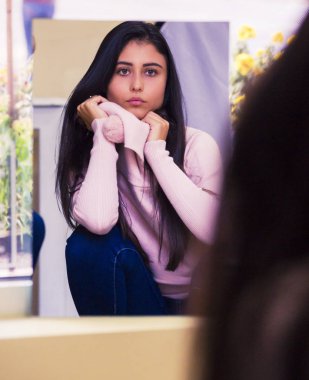 Güzel, genç bir bayan esmer model. Aynada kendine bak.