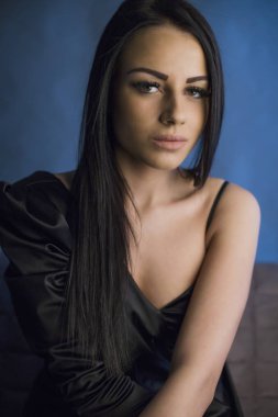 Mavi arka planda poz veren güzel genç bir kadının portresi. 