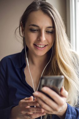 Kadın akıllı telefonuyla video görüşmesi yapıyor.