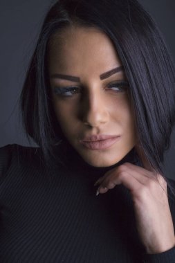 Çekici esmer kadın kameraya poz veriyor.