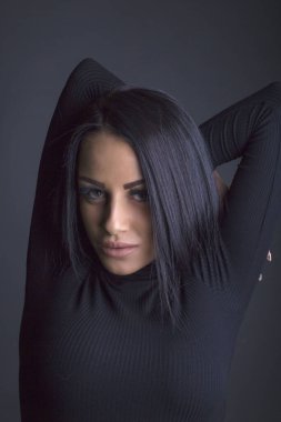 Çekici esmer kadın kameraya poz veriyor.