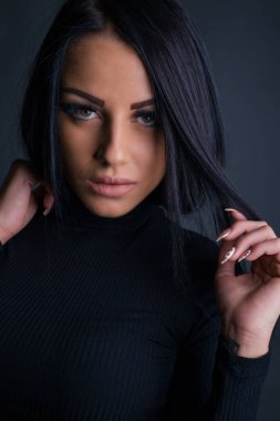 Çekici esmer kadın kameraya poz veriyor.