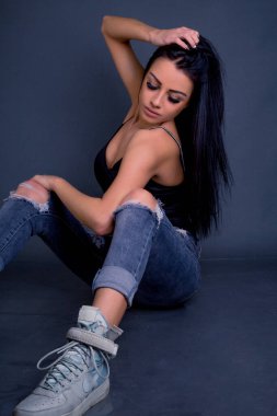 Çekici esmer kadın kameraya grunge kotla poz veriyor.