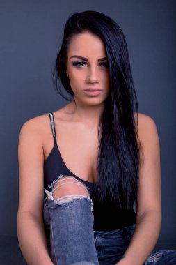 Çekici esmer kadın kameraya grunge kotla poz veriyor.