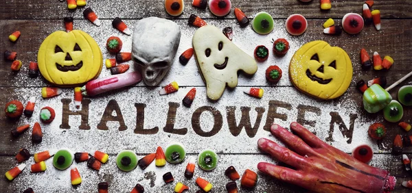 Doces, biscoitos e palavra Halloween — Fotografia de Stock
