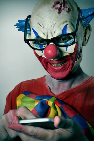 Злий клоун за допомогою смартфона — стокове фото