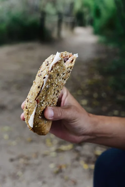 Jovem comendo um sanduíche ao ar livre — Fotografia de Stock