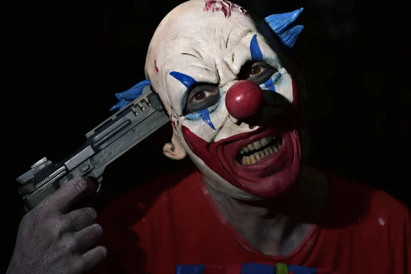 Böser Clown, der eine Waffe auf seine Schläfe richtet — Stockfoto