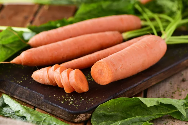 Rauwe wortelen op een snijplank — Stockfoto