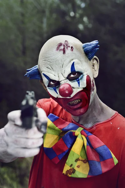 Gruseliger böser Clown mit Waffe — Stockfoto
