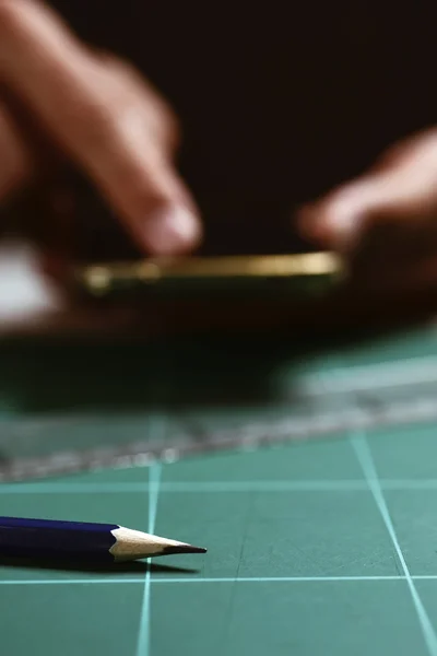 Man met zijn smartphone op zijn werkplek — Stockfoto