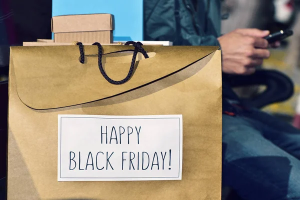 Man and bag with the text happy black friday — Stock Photo, Image