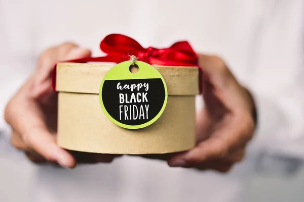 Man with a gift box with the text black friday — Stock Photo, Image