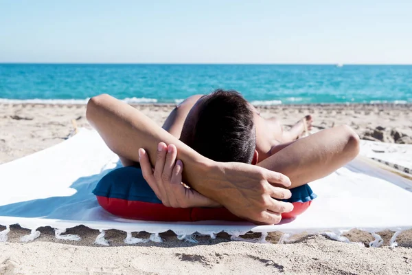 Молодий чоловік засмагає на пляжі — стокове фото
