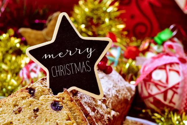 Fruitcake ολοκληρώνεται με μια πινακίδα με το κείμενο καλά Χριστούγεννα — Φωτογραφία Αρχείου