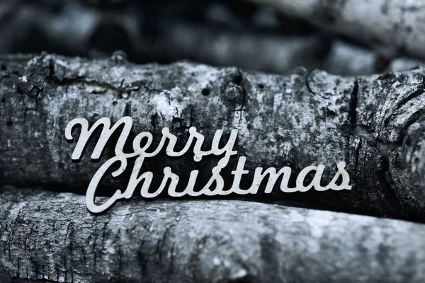Text merry christmas and pile of logs — Stock Photo, Image