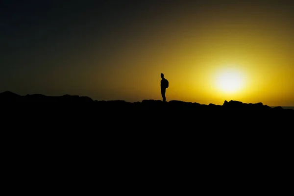 Silhouette eines jungen Mannes in der Dämmerung — Stockfoto