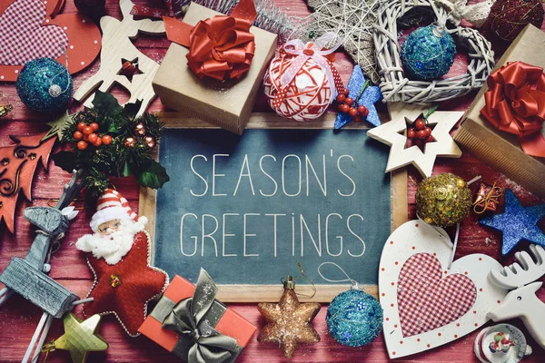 Ornaments and gifts and text seasons greetings — Stock Photo, Image