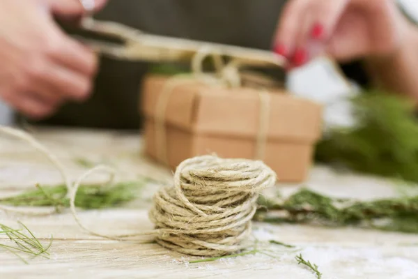 Frau bindet eine Schnur um ein Geschenk — Stockfoto