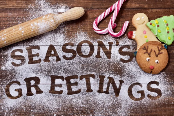 Galletas de Navidad y saludos de las temporadas de texto — Foto de Stock