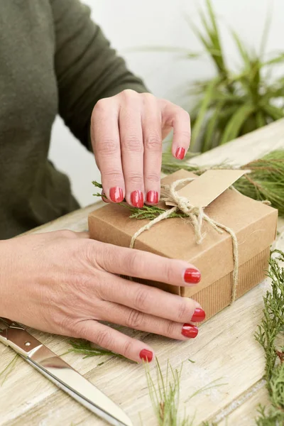 Donna legare una stringa intorno a un regalo — Foto Stock