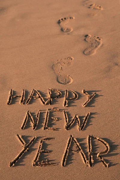 Text Frohes Neues Jahr im Sand eines Strandes — Stockfoto