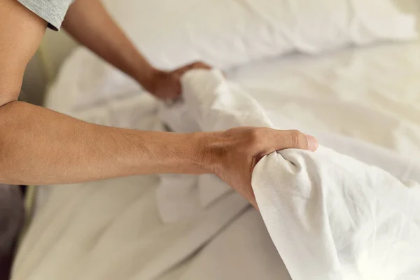 Young man making the bed — Stock Photo, Image