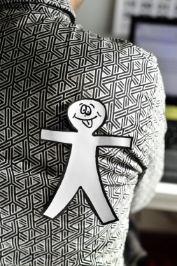 young man with a paper man attached to his back clipart
