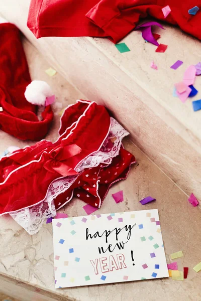 Confetti, red underwear and text happy new year — Stock Photo, Image