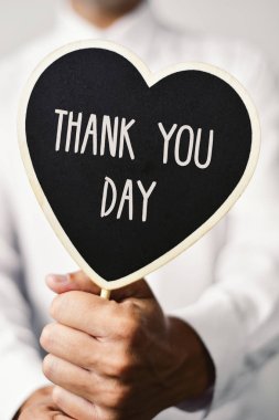 man with signboard with the text thank you day clipart