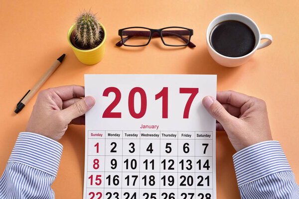 молодой бизнесмен с календарем 2017 года
