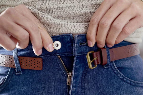 Joven tratando de abrocharse los pantalones —  Fotos de Stock