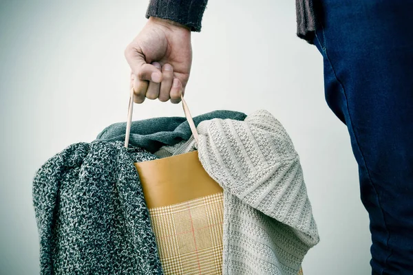 Homem com um saco de compras com roupas — Fotografia de Stock