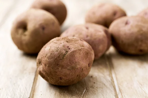 Batatas não descascadas cruas em uma mesa — Fotografia de Stock
