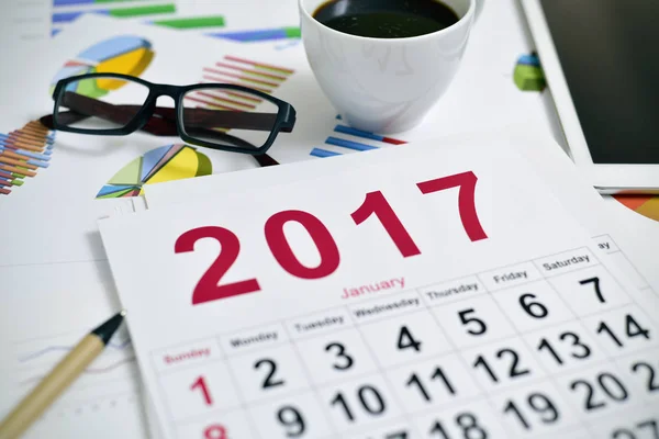 Eyeglasses, coffee, tablet charts and 2017 calendar — Stock Photo, Image