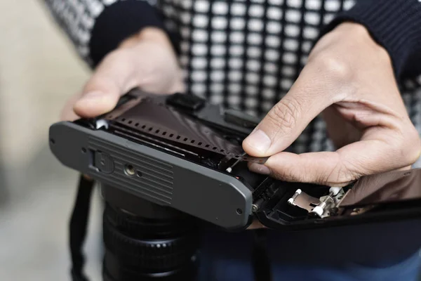 Mann wechselt den Rollfilm seiner Kamera — Stockfoto