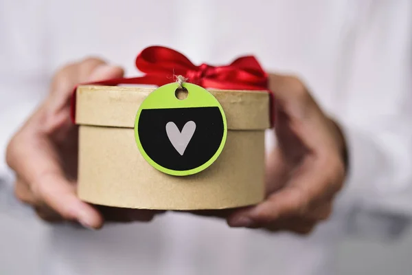 Man with a gift with a heart — Stock Photo, Image