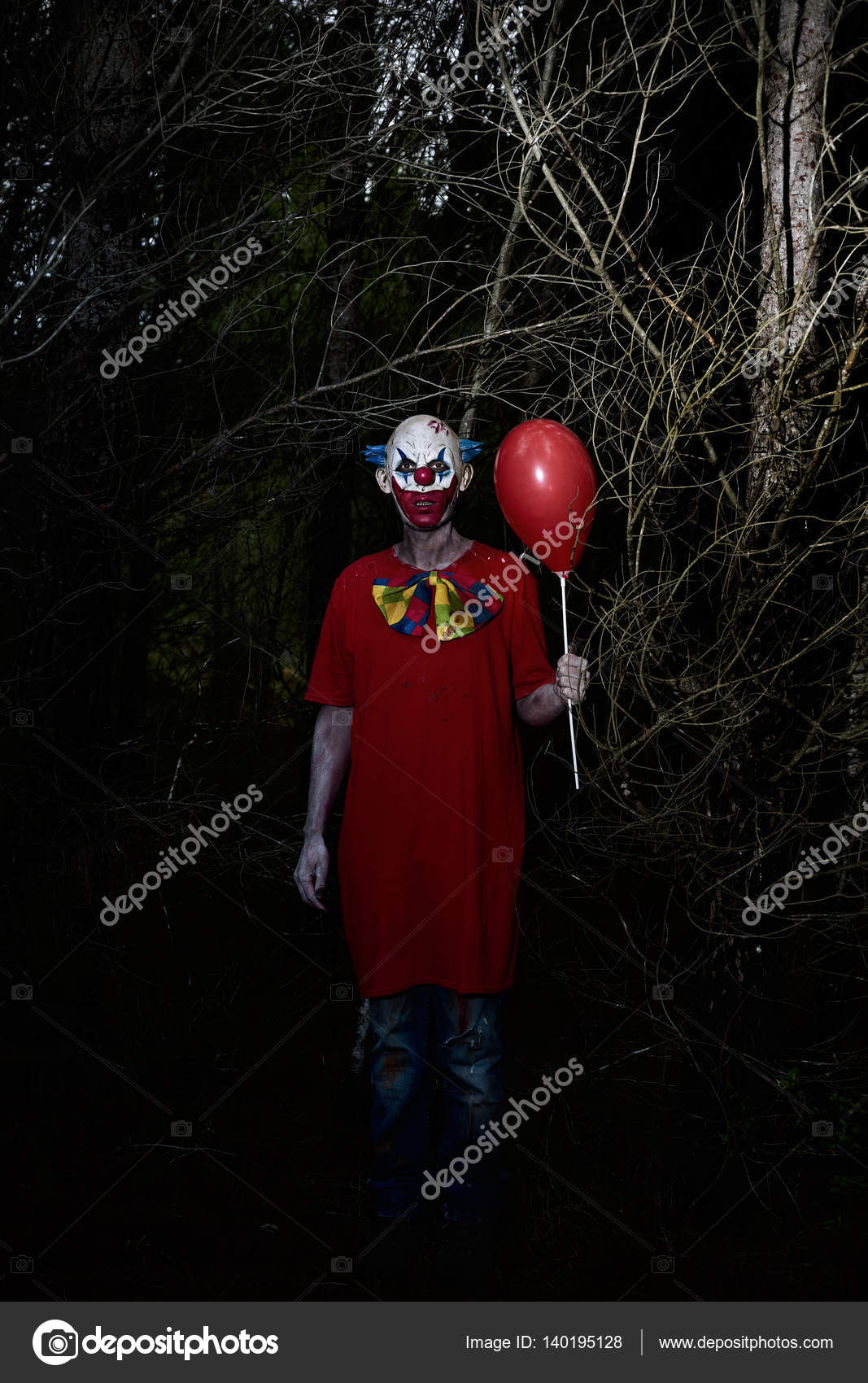 Scary evil clown in the woods at night Stock Photo by ©nito103 140195128
