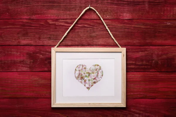 Quadro com um coração em uma parede de madeira — Fotografia de Stock