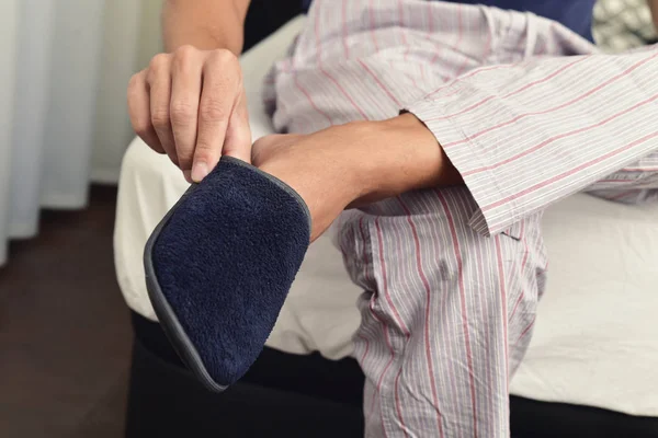 Young man putting on his slippers — Stock Photo, Image