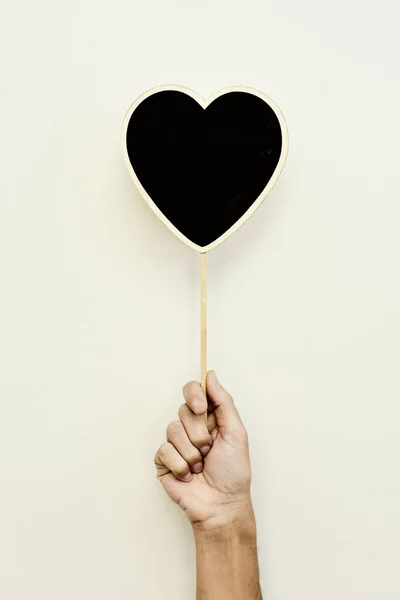 Man with a blank heart-shaped signboard — Stock Photo, Image