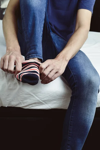 Молодой человек надевает или снимает носки — стоковое фото
