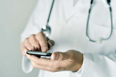 bir akıllı telefon kullanan doktor adam