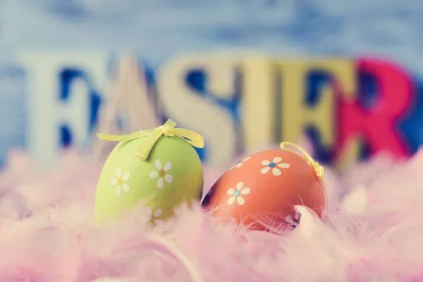 Decorated eggs, feathers and word easter — Stock Photo, Image