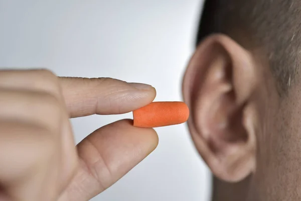 Man putting on an earplug — Stock Photo, Image