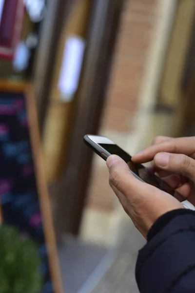 Man använder en smartphone framför en restaurang — Stockfoto
