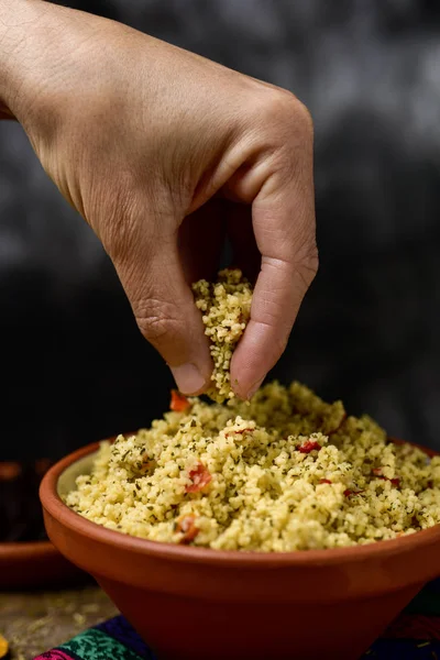 Fiatal ember eszik tabbouleh kezével — Stock Fotó